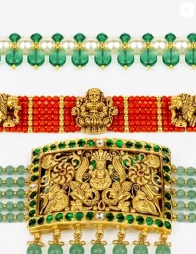 A coral bead choker with gold elephants and a carved clasp panel.