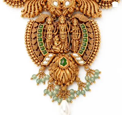 A devotional gold pendant with deity figures, green beads and a pearl drop.