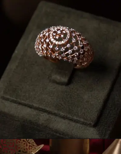 A diamond dome ring standing in a green velvet box.