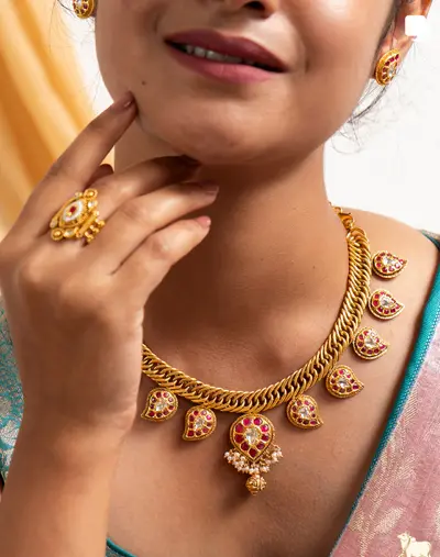 The kundan mango necklace worn with a teal silk saree.