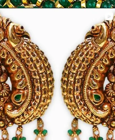 A pair of repousse peacock earrings with pearls and green beads.