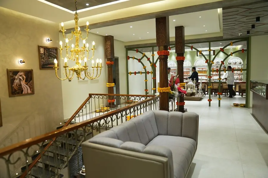The upper floor: a chandelier, marigold wound pillars and a long sofa.